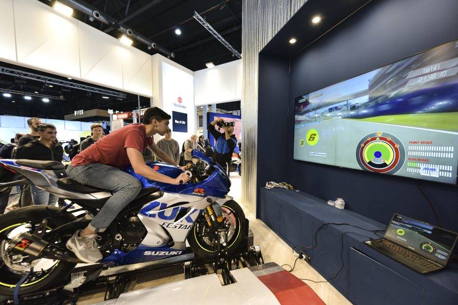 Un joven sobre una GSX-R concrentrao en la pantalla del simulador Un joven sobre una GSX-R concrentrao en la pantalla del simulador