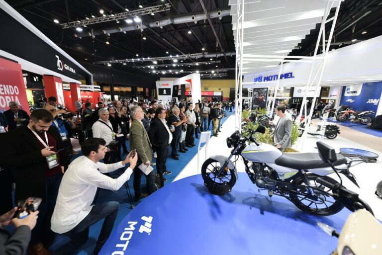Un modelo de la marca motomel de color blanco es fotografiado en su stand por un visitante al Salón Moto 2023