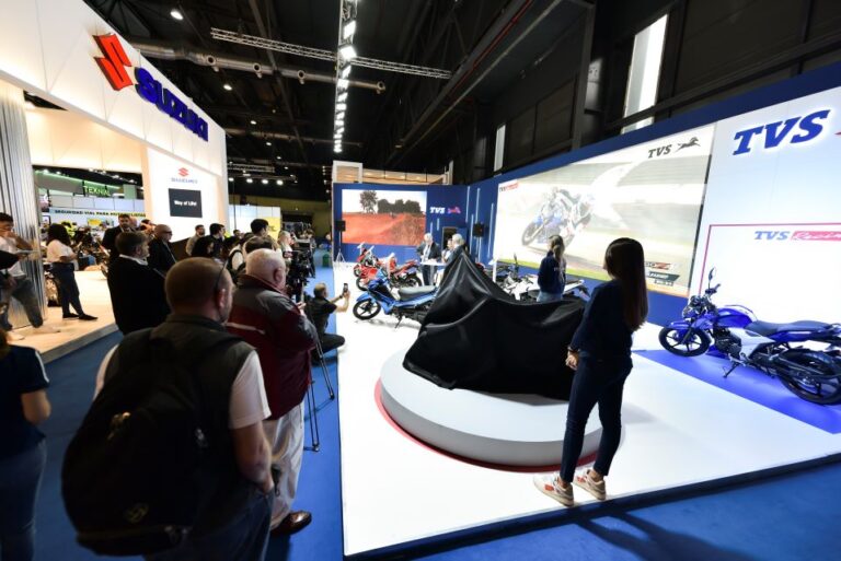 En perspectiva, un stand del Salón Moto 2023, la prensa espera el lanzamiento de una moto, aún cubierta