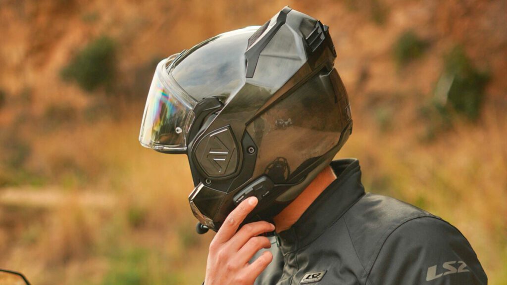 Una persona con el casco LS2 4X puesto señala el intercomunicador
