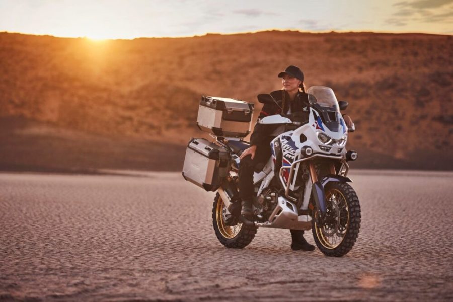 Una mujer con gorra sobre la Honda Africa Twin 2024 blanca, azul y roja Una mujer con gorra sobre la Honda Africa Twin 2024 blanca, azul y roja
