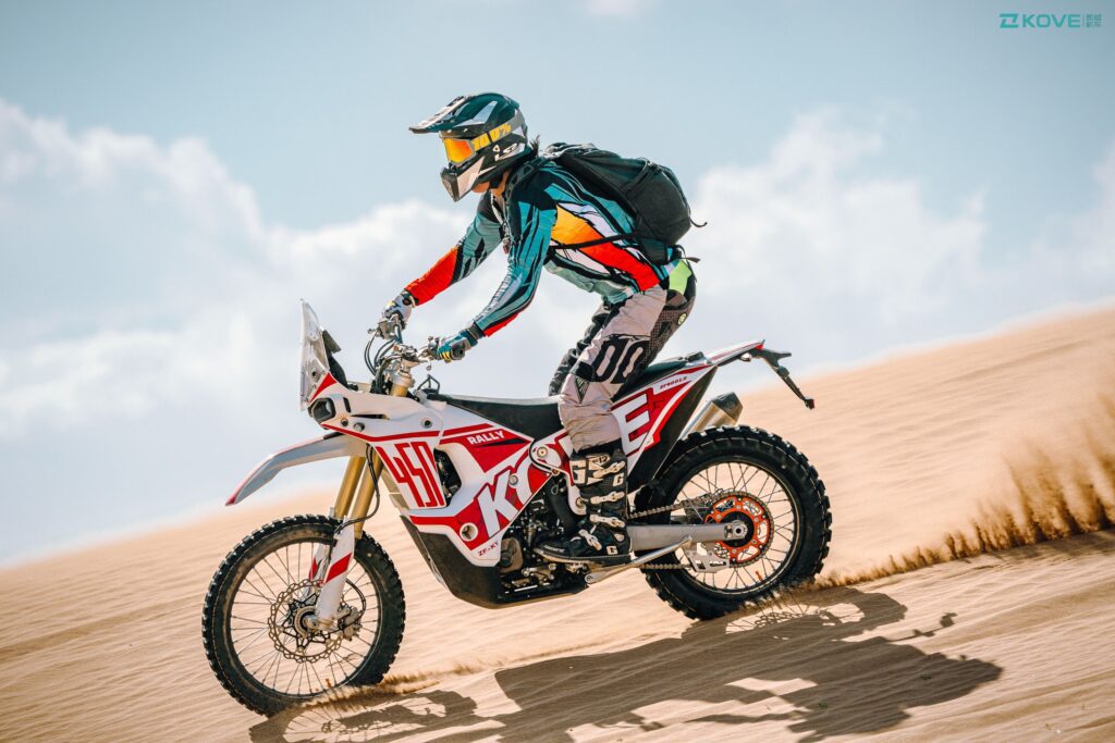 Piloto parado sobre los pedalines lleva una Kove 450 Rally por el desierto