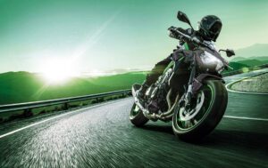 Kawasaki Z900 verde encara una curva en la ruta