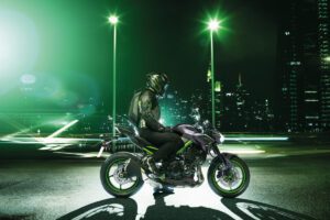 Conductor de una Kawasaki Z900 espera sentado en la moto de noche 