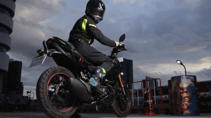 Un motociclista sobre una moto naked mira hacia atrás con el casco puesto