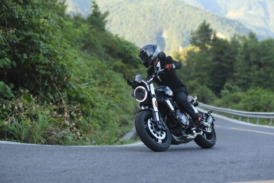 Hombre de traje negro sobre una Cyclone en una carretera
