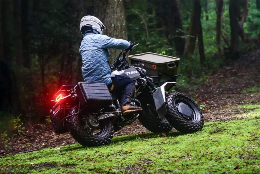 <img src="https://motodinamia.com/wp/wp-content/uploads/2024/01/Yamaha-TMW-mdm-3-scaled.jpeg" alt="El TMW, cuyo nombre incorpora la 'M' de la serie TW de Yamaha, presenta una estética llamativa y un carácter Scrambler, apoyado por varios componentes. Desde los neumáticos hasta las maletas laterales y el baúl, cada elemento refleja su vocación aventurera">