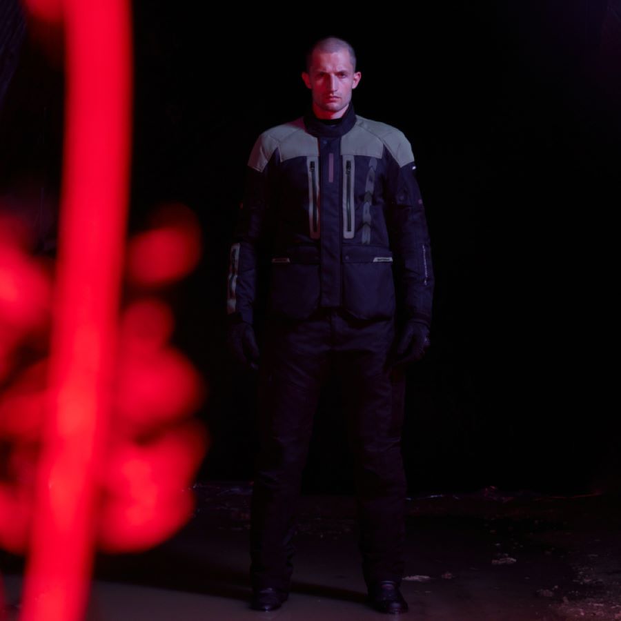 Hombre parado en penumbras con una chaqueta SPIDI Traveler 3 Evo azul y gris