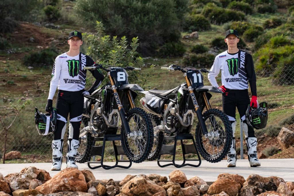 Dos pilotos posan junto a sus Triumph TF 250 X