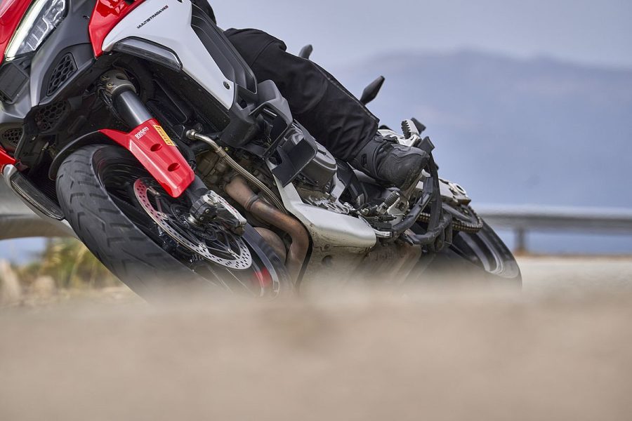 Una moto roja y blanca con neumáticos Pirelli Scorpion Trail III en acción