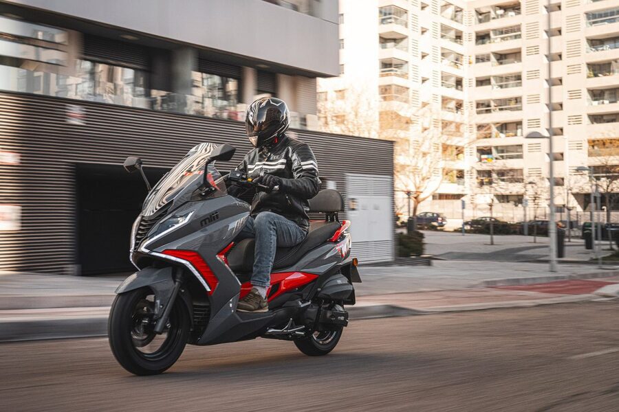 Un scooter Mitt GT Max 330 con sus colores gris y rojo transita por una calle