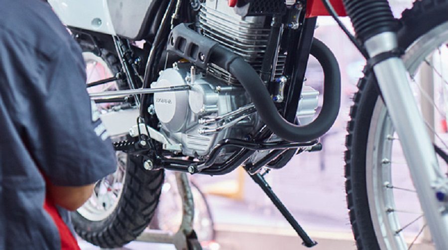 Mecánico repara el motor de una moto. Mecánico repara el motor de una moto.