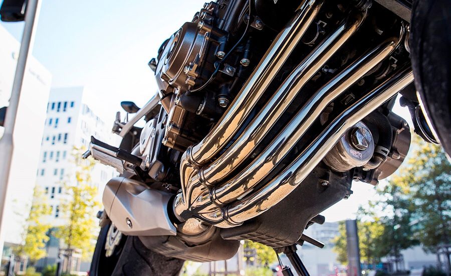 Cuatro largos escapes cromados recorren la base y el costado de una moto 