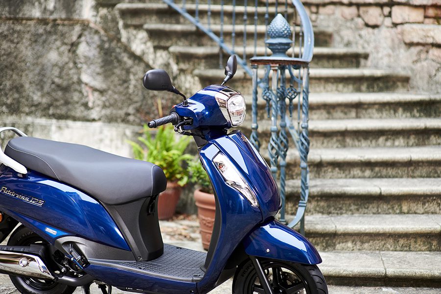 Un Suzuki Address 125 azul estacionado cerca e una antigua escalera de piedra Un Suzuki Address 125 azul estacionado cerca e una antigua escalera de piedra