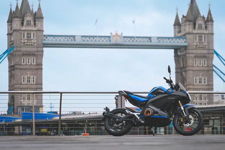 Una Vmoto Stash azul con el Tower Bridge de Londres de fondo.