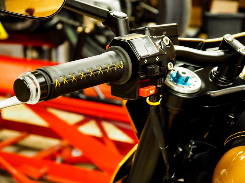 Un puño de la Yamaha V-Max 1200 Rage forrado en cuero negro con costuras