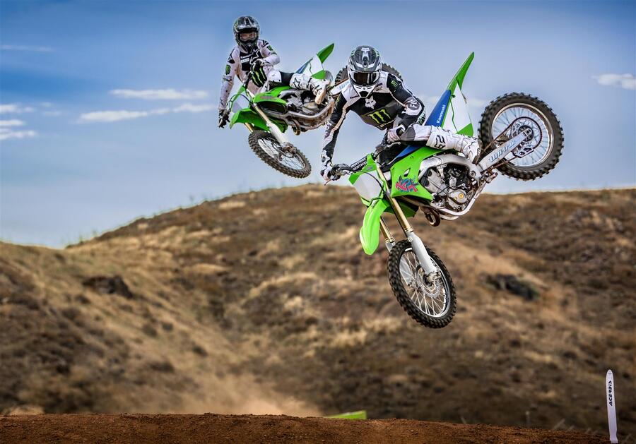 Dos pilotos en sus KX450 saltan en paralelo en una pista Dos pilotos en sus KX450 saltan en paralelo en una pista