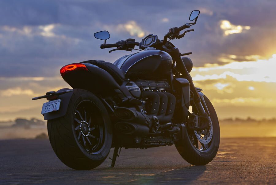 Una Triumph Rocket 3 Storm 2024 vista en perspectiva desde atrás y con el cielo de un atardecer de fondo Una Triumph Rocket 3 Storm 2024 vista en perspectiva desde atrás y con el cielo de un atardecer de fondo