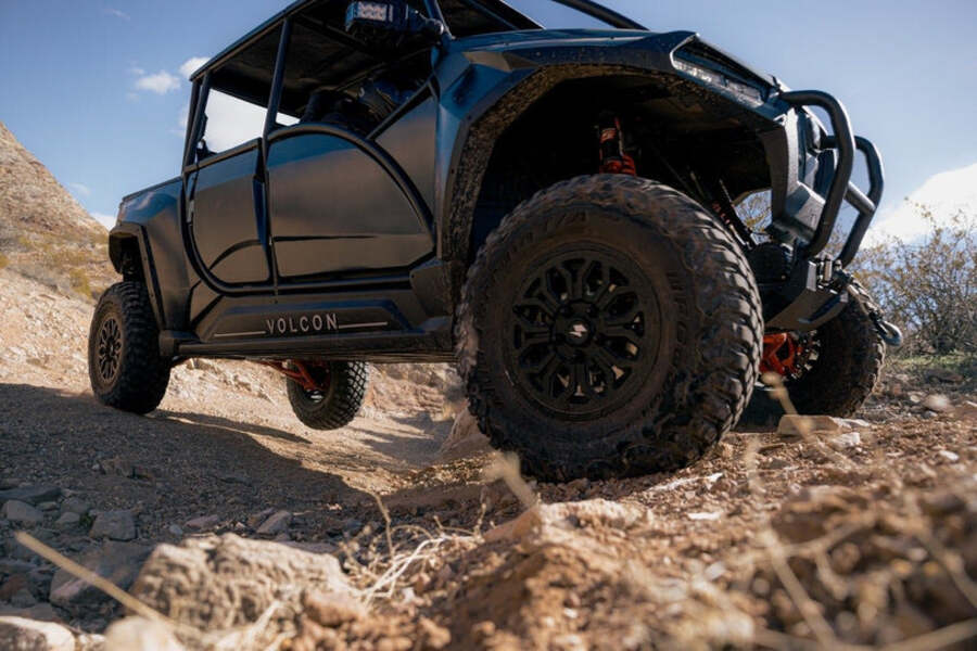 Un UTV Volcon Stag totalmente oscuro trepa un terreno escarpado Un UTV Volcon Stag totalmente oscuro trepa un terreno escarpado