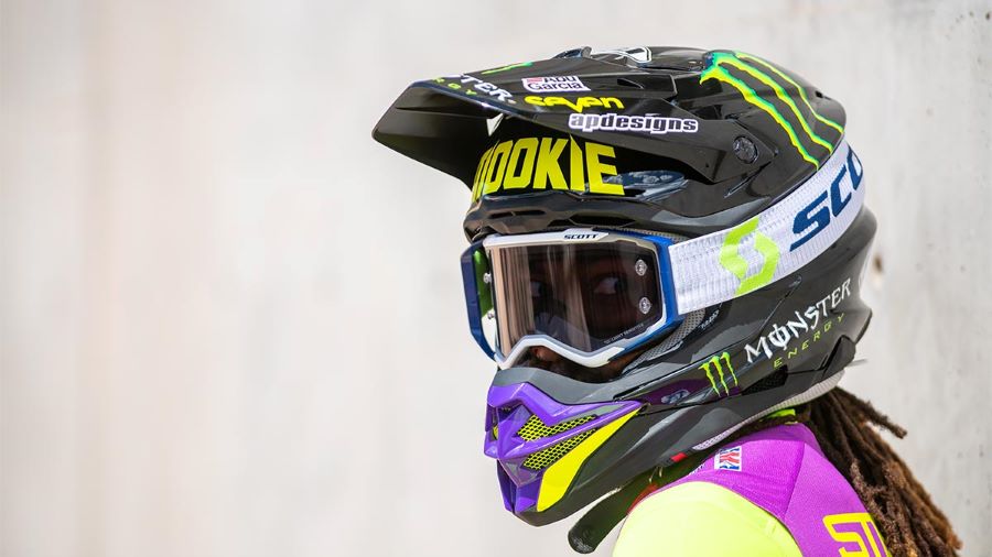 Una mujer monta un colorido casco integral con la antiparras Scott Prospect Light Sensitive.