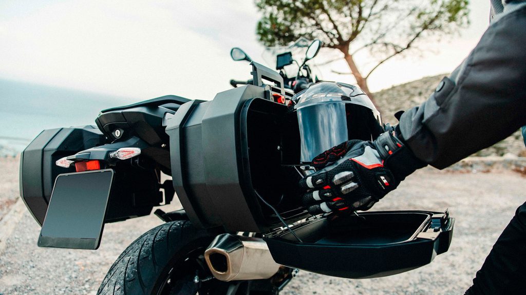 Un motociclista introduce un casco en una maleta SHAD SH38X Expandable.