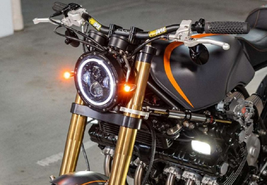Dos micro indicadores Omni Lights brillan a la par de una faro de una moto retro modificada