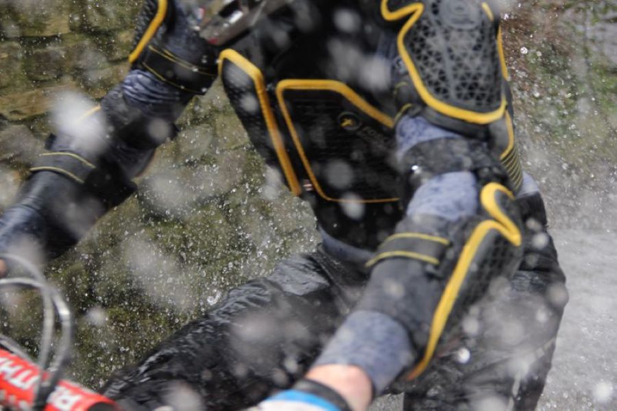 Un piloto atraviesa un espejo de agua con el peto integral Forcefield EX-K Harness Adventure.