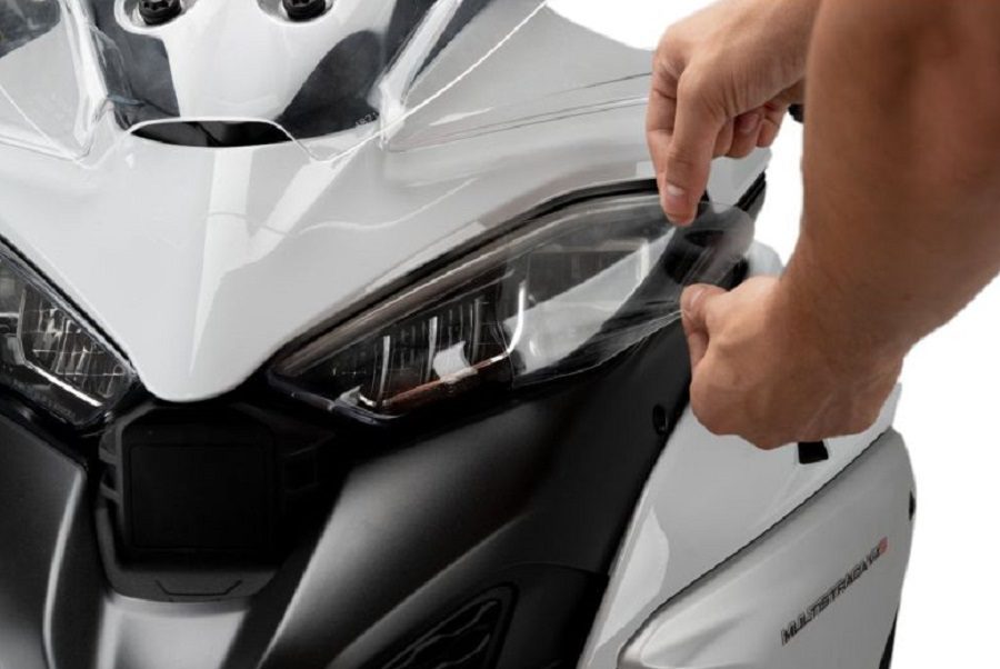 Aplicación del protector de faro Adhere de Puig en una Ducati Multistrada blanca.