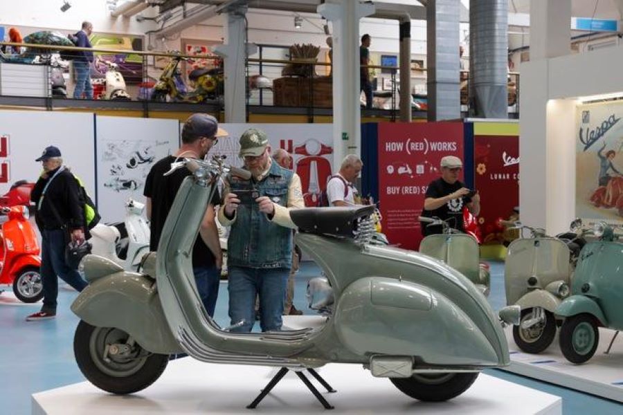Una antigua Vespa color verde en primer plano en el Museo Piaggio.
