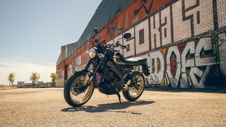 Yamaha XSR125 Legacy estacionada frente a un pared con un Graffiti