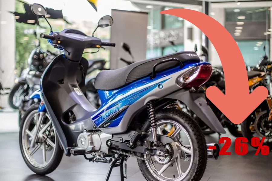 Una moto CUB azul en un concesionario. A su derecha una flecha descendente indicando la baja del 26% en los patentamientos.