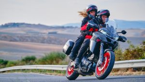 una pareja se transporta en una moto touring por una ruta de montaña