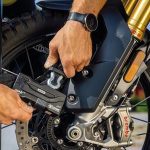 ¿Cuál es la mejor cadena antirrobo para moto? Una persona fija su moto con un candado de máxima seguridad.
