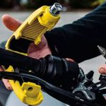 Una persona coloca el sistema antirrobo de candado para puño, que sujeta el mismo con la maneta de embrague.