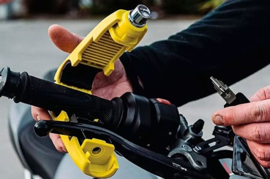 Una persona coloca el sistema antirrobo de candado para puño, que sujeta el mismo con la maneta de embrague.