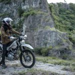 Kawasaki KLX230 Sherpa y DF: entre lo urbano y off-road Una usuaria con su Kawasaki KLX230 Sherpa blanca se para a observar el paisaje montañoso