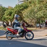 Mi moto 110 no arranca y tiene chispa: causas y soluciones Una mujer con ropa de jeans se desplaza en una Motomel Blitz 110 roja