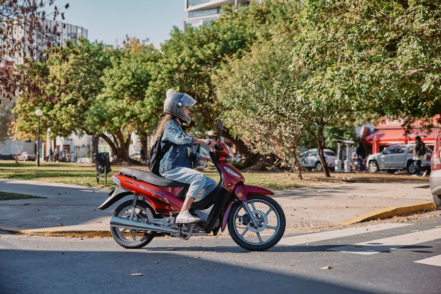 Motomel Blitz 110 Una mujer con ropa de jeans se desplaza en una Motomel Blitz 110 roja