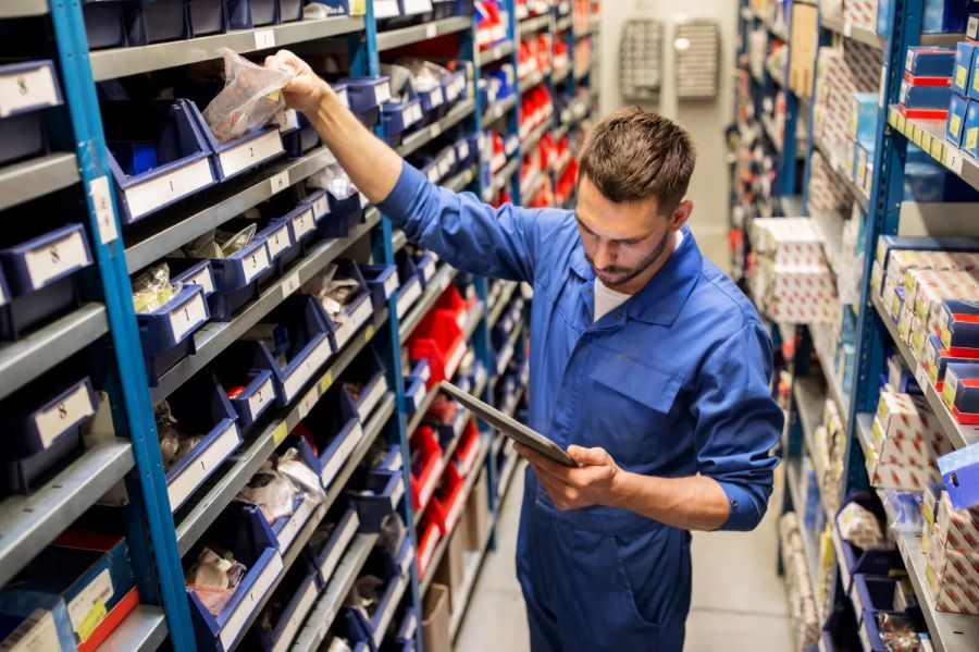 Un empleado de un negocio de venta de repuestos de motos trabaja en la reposición de productos.