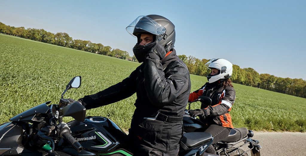 Un motociclista se acomoda el intercomunicador en el que está escuchando música junto a su compañera de viaje, que va en otra moto