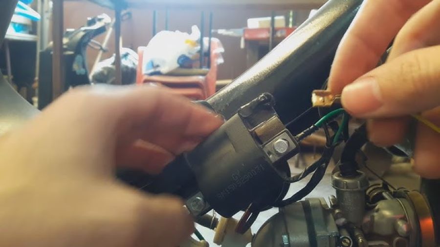 Lss manos de un operario manipulan los cables de un corta corriente de moto