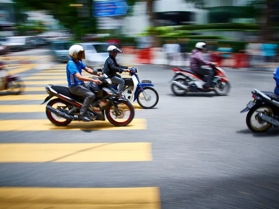 Un grupo de motociclistas acaba de cruzar una senda peatonal amarilla