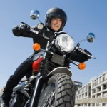 Cómo aprender a manejar moto para mujer Una toma delantera de una mujer en moto con casco jet