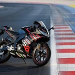 Nueva réplica de la Aprilia RS 125 GP: una MotoGP mínima Una Aprilia RS 125 GP Replica 2025 posa en una pista junto al "pianito2 rojo y blanco