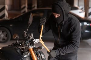 Un hombre encapuchado, con una gran tijera en las manos, intenta robar una moto