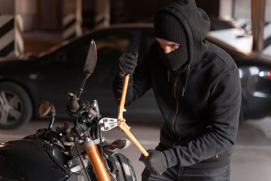 Un hombre encapuchado, con una gran tijera en las manos, intenta robar una moto