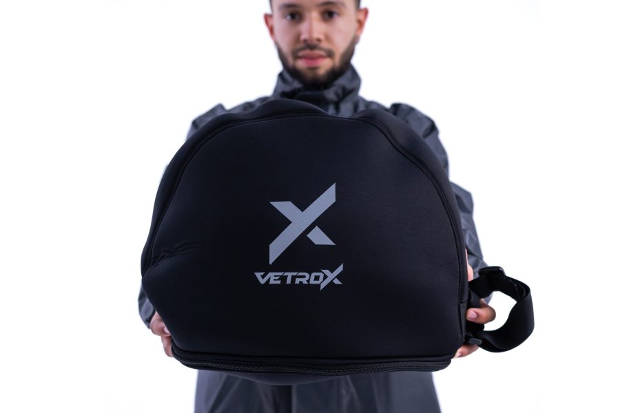 Una persoa co las manos extendidas muestra un casco dentro de una funda protectora negra