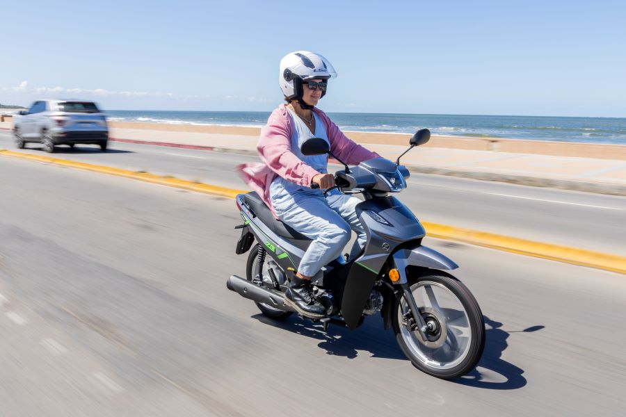 Una joven sobre una Zanella ZB 2025 avanza por una avenida costera
