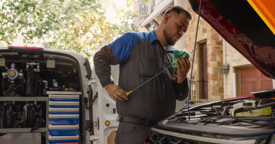 Un operario mecánico mide el aceite de un auto