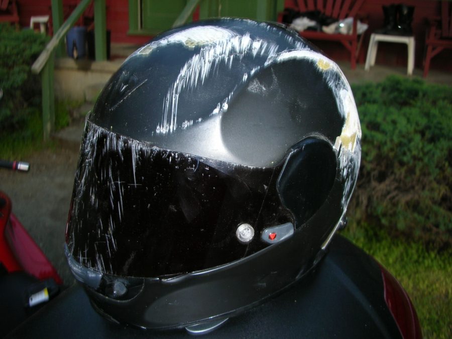 Casco de moto con múltiples ralladuras y golpes